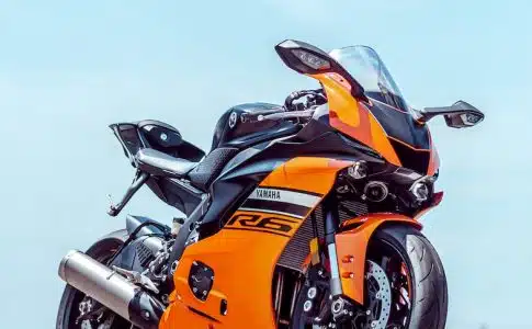 orange and black sports bike parked on gray concrete pavement during daytime