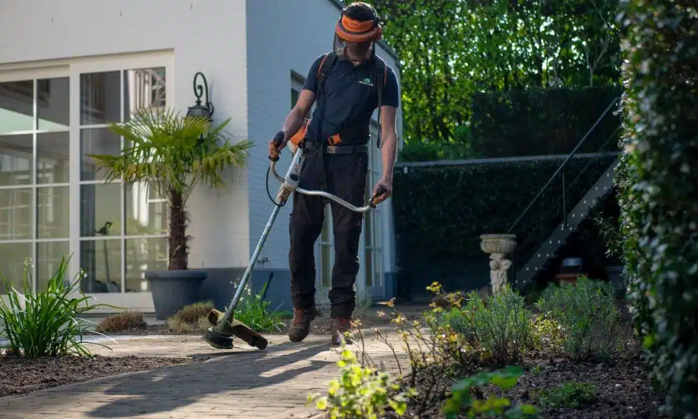 man in black t-shirt and blue denim jeans holding shovel