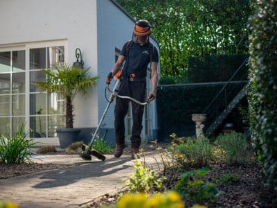 man in black t-shirt and blue denim jeans holding shovel