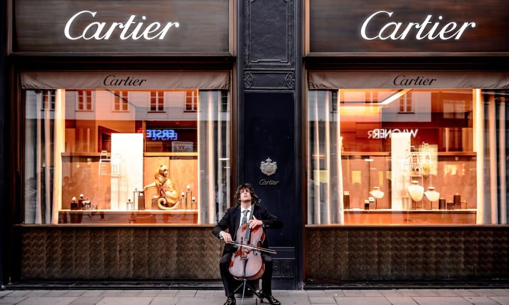 man playing cello in front of store
