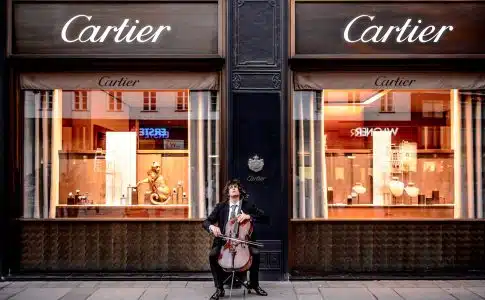 man playing cello in front of store